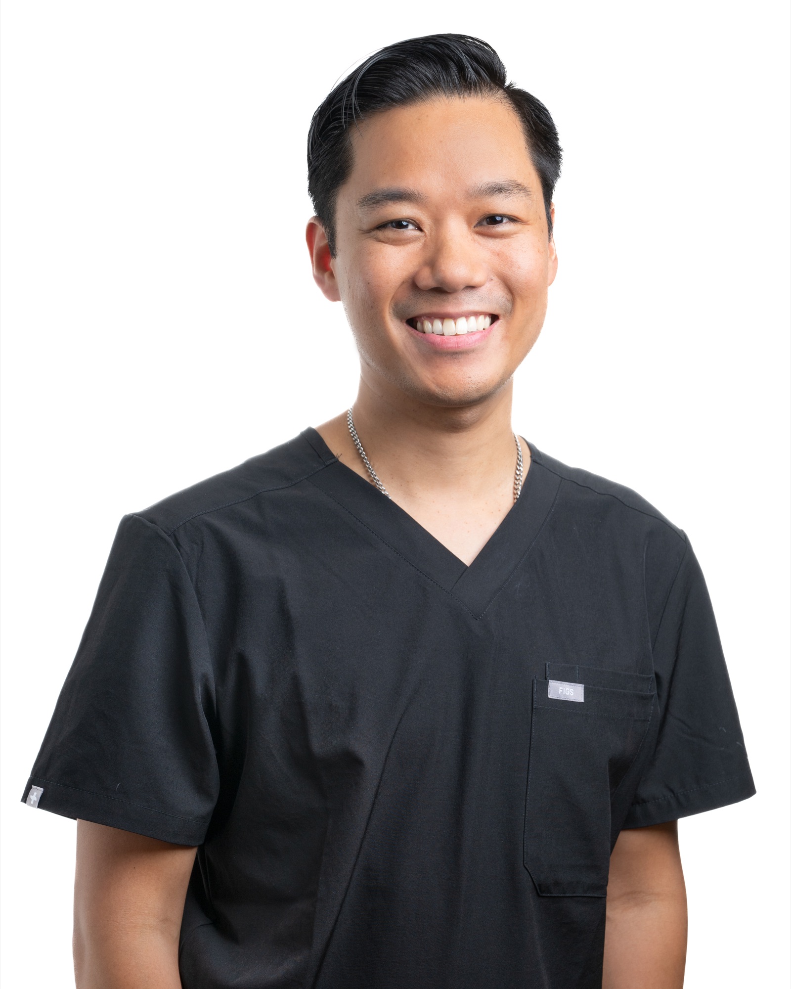 Dr Jonathan Tey, Specialist General Practitioner, smiling in black scrubs